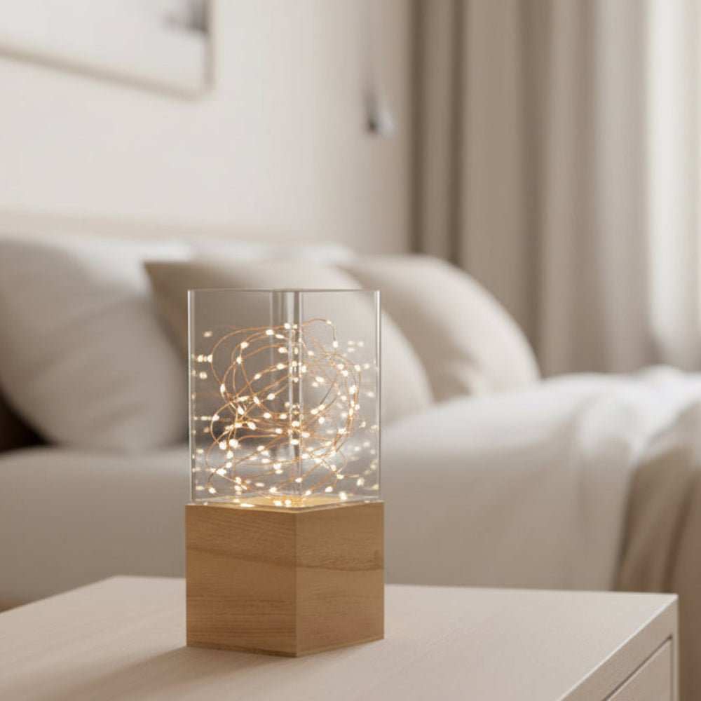 ljuslykta i glas och trä på sängbord i sovrum